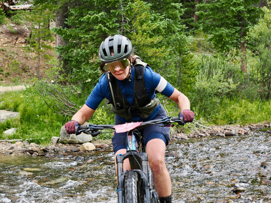 Nora crossing a river during the Breck Epic mountain bike race