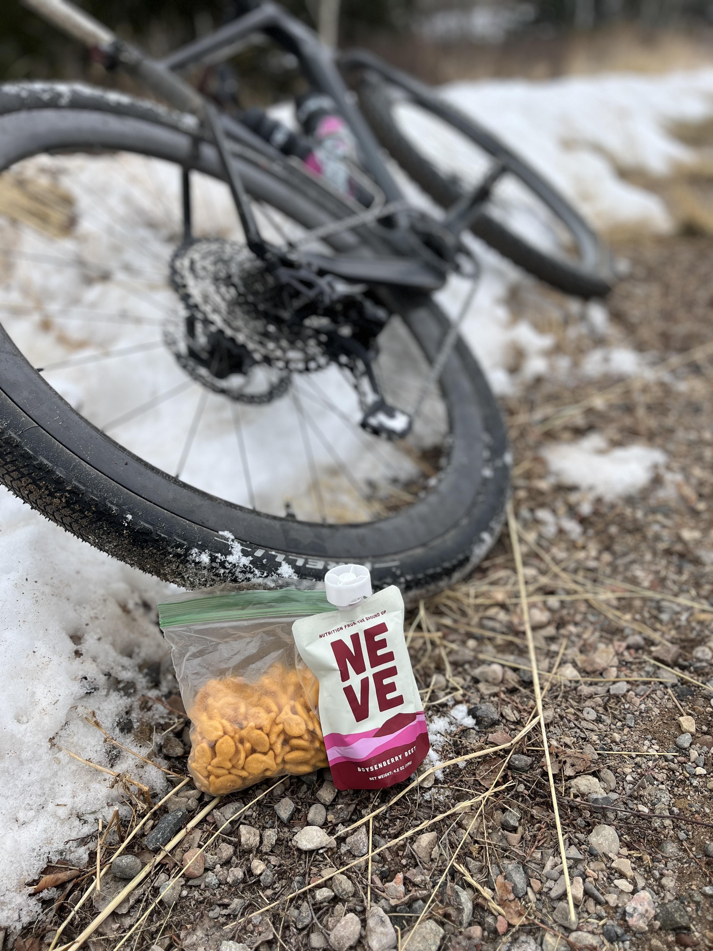 Boysenberry Beet Neve Smoothie Pouch for Athletes next to Goldfish and a mountain bike
