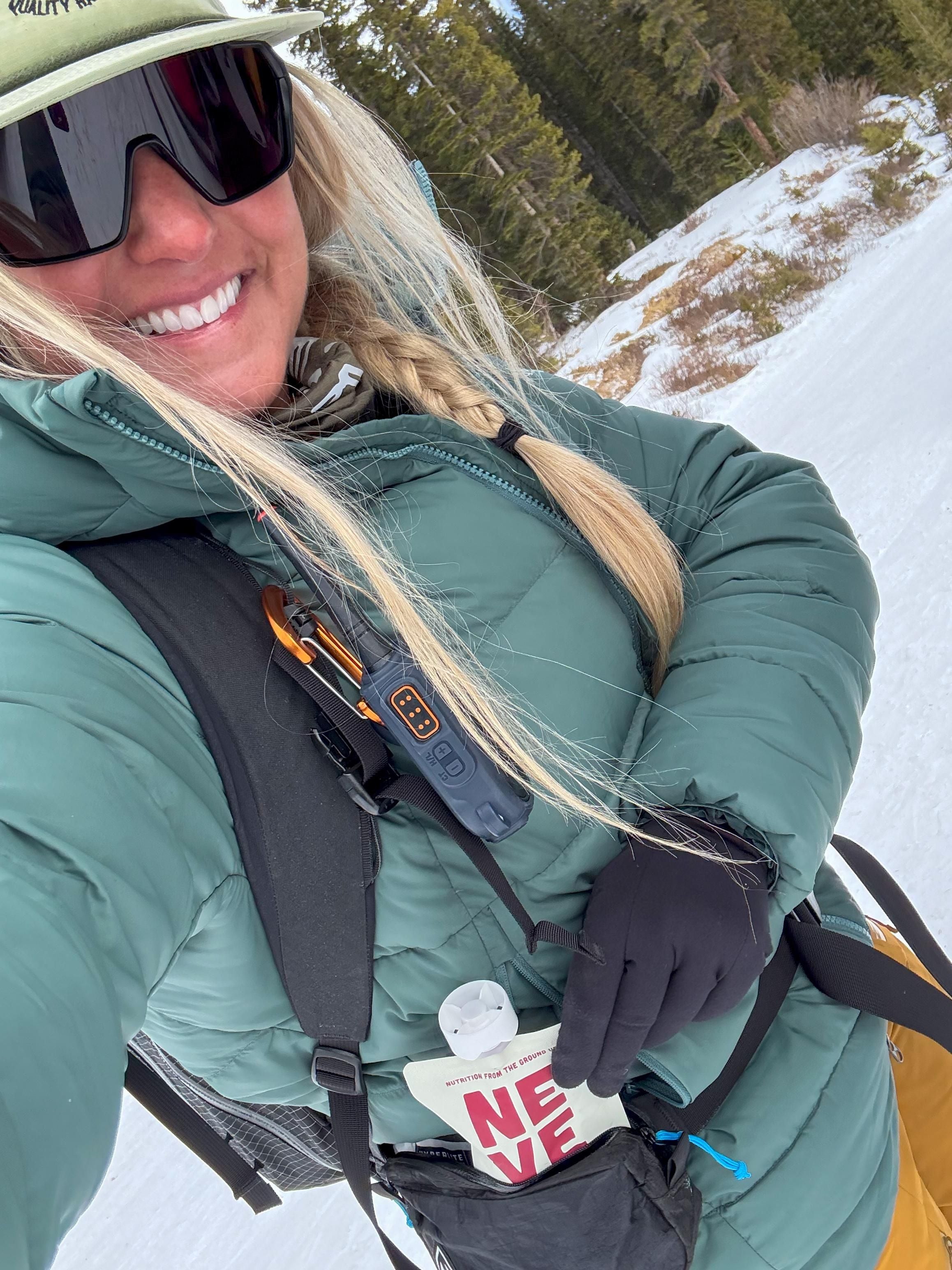 Boysenberry Beet Neve Smoothie Pouch taken out of hip pocket by a backcountry skier