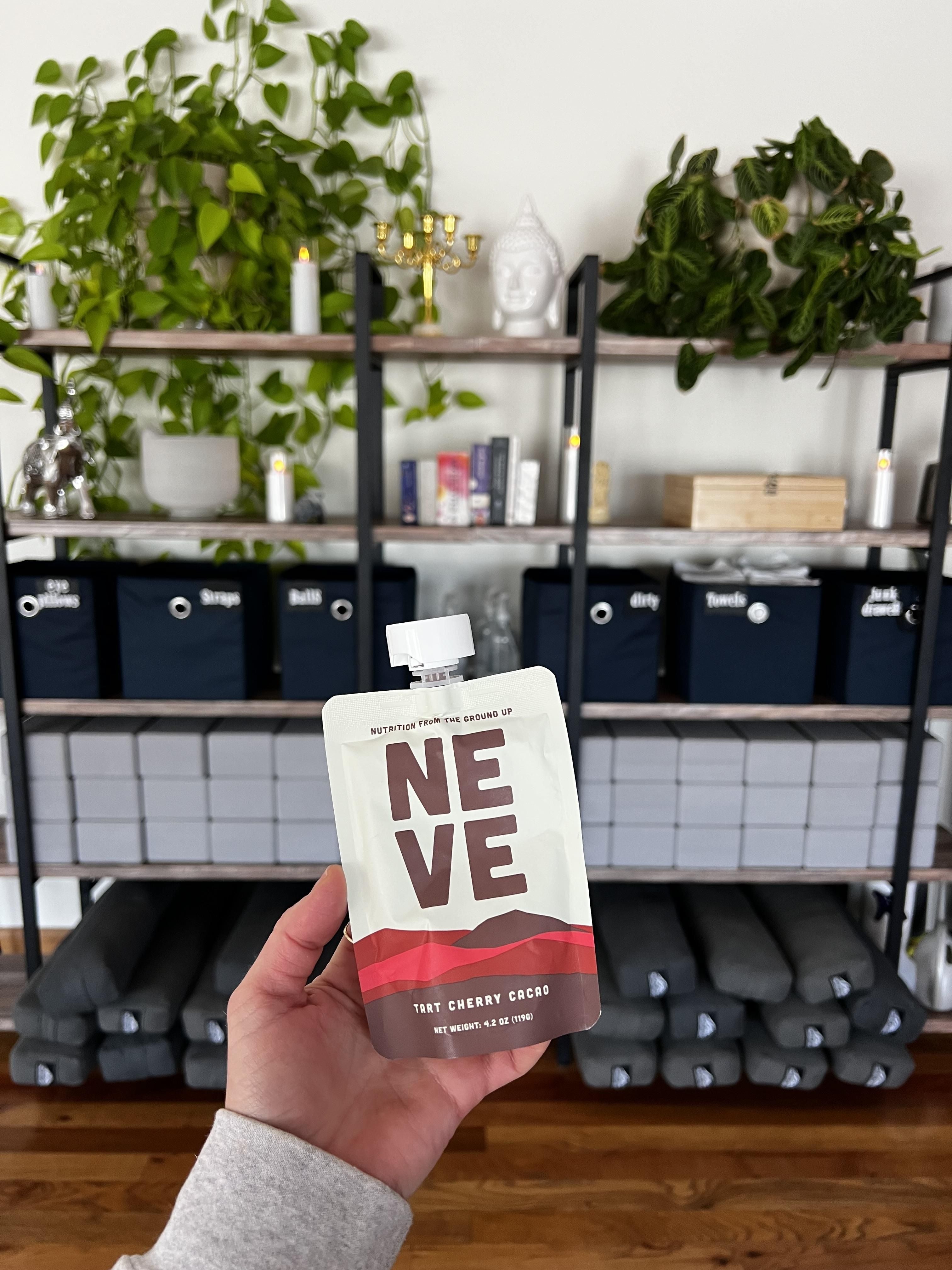 Tart Cherry Cacao recovery smoothie pouch held up at yoga studio