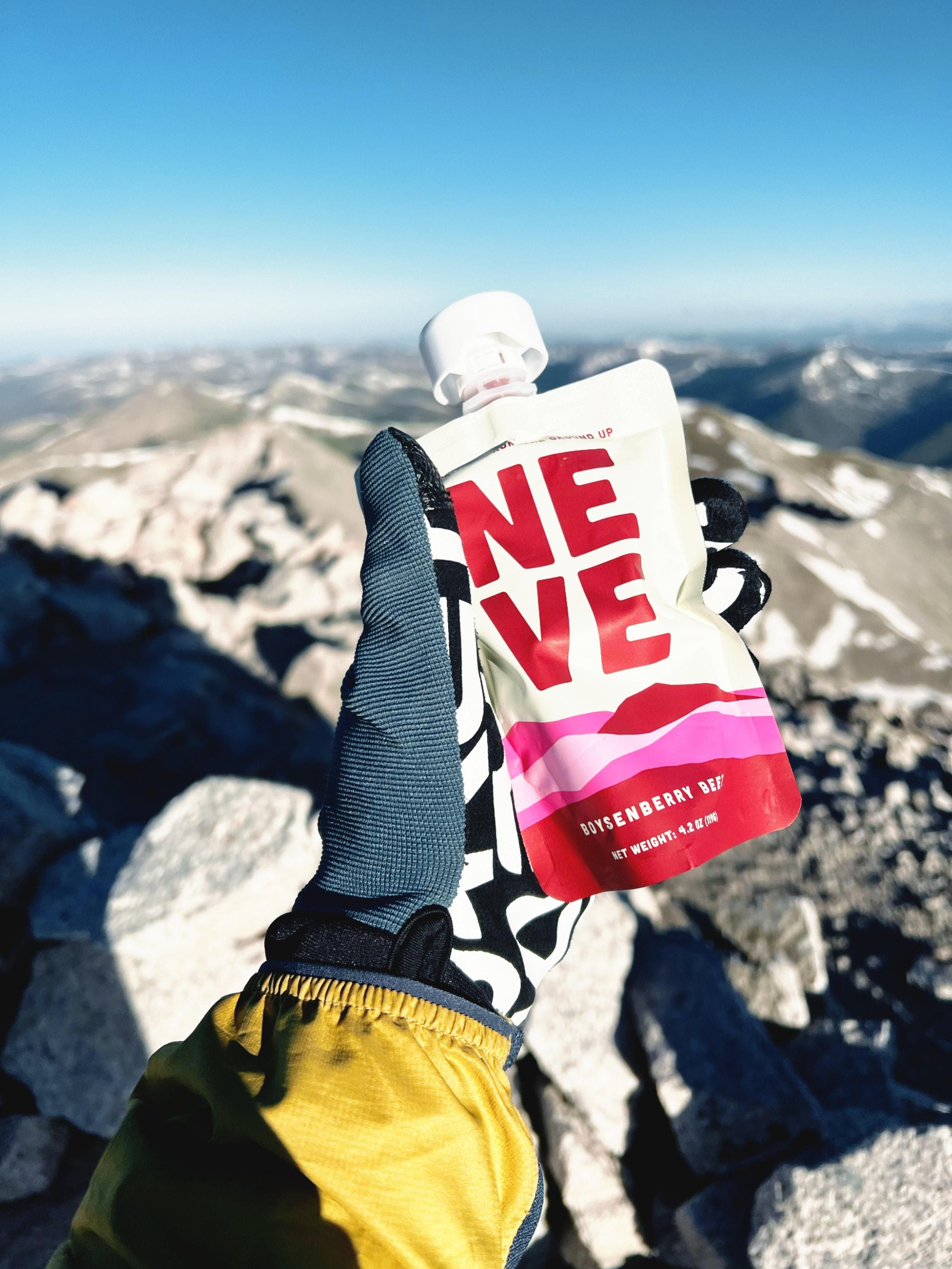 Neve Boysenberry Beet Smoothie Pouch on a mountain top