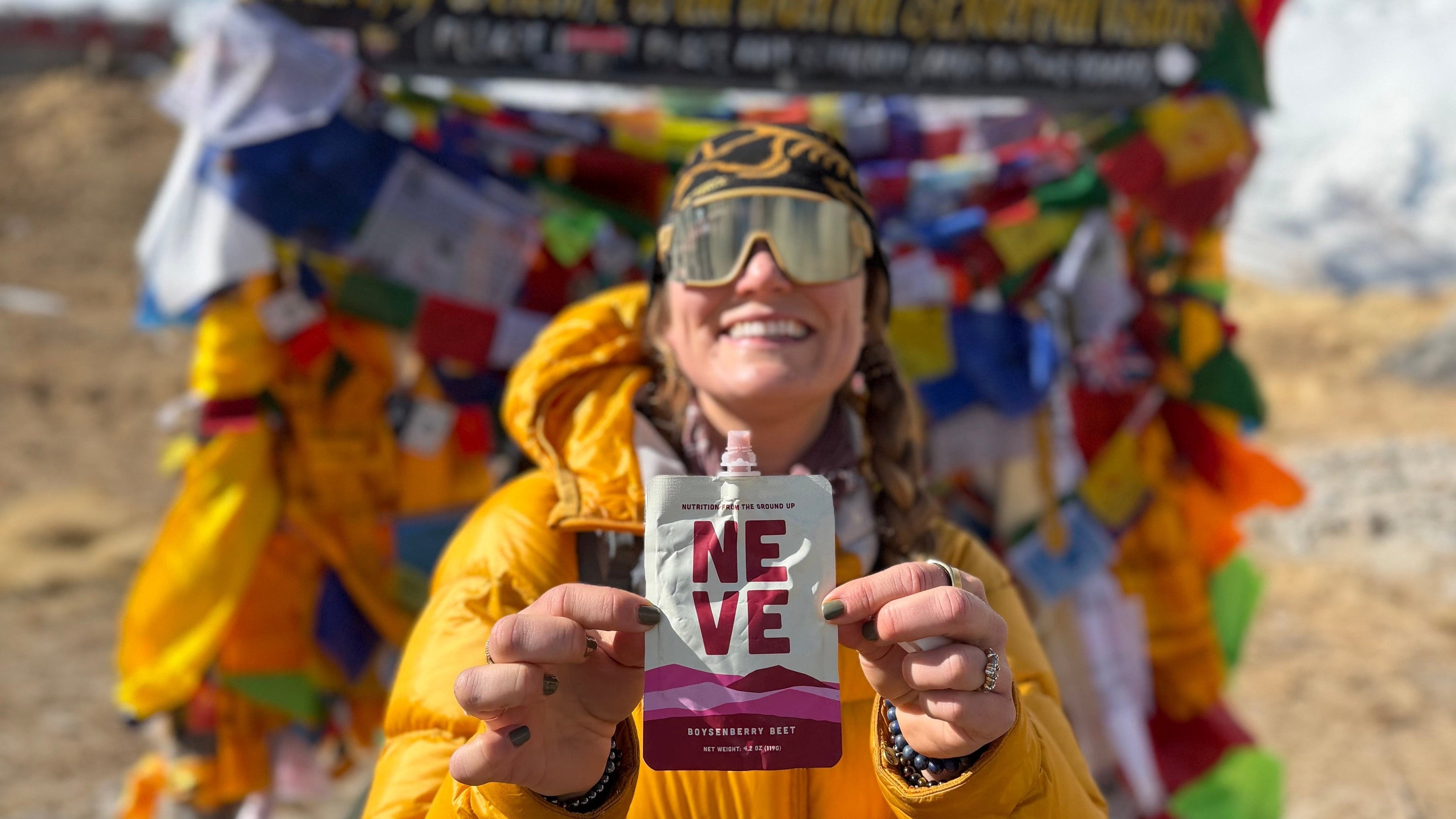 Allie holding Boysenberry Beet in front of AnnaPurna Basecamp sign