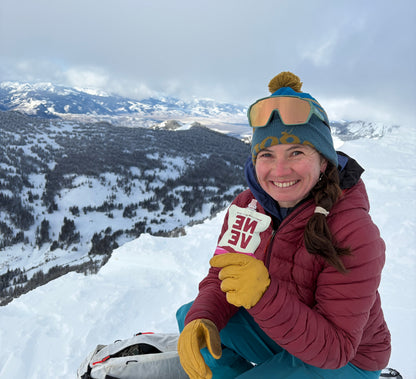 Image of professional biker Kate Boyle with Boysenberry Beet Neve Pouch while skiing.