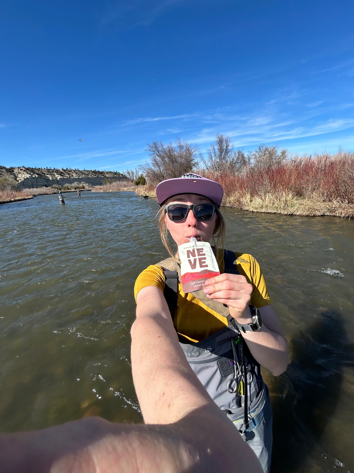 Fisherwoman uses Neve Tart Cherry Cacao Recovery Smoothie Pouch while fishing