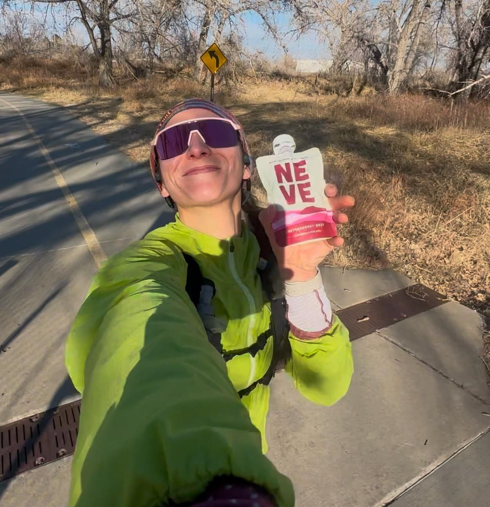Runner holding up Boysenberry Beet Smoothie pouch on a run