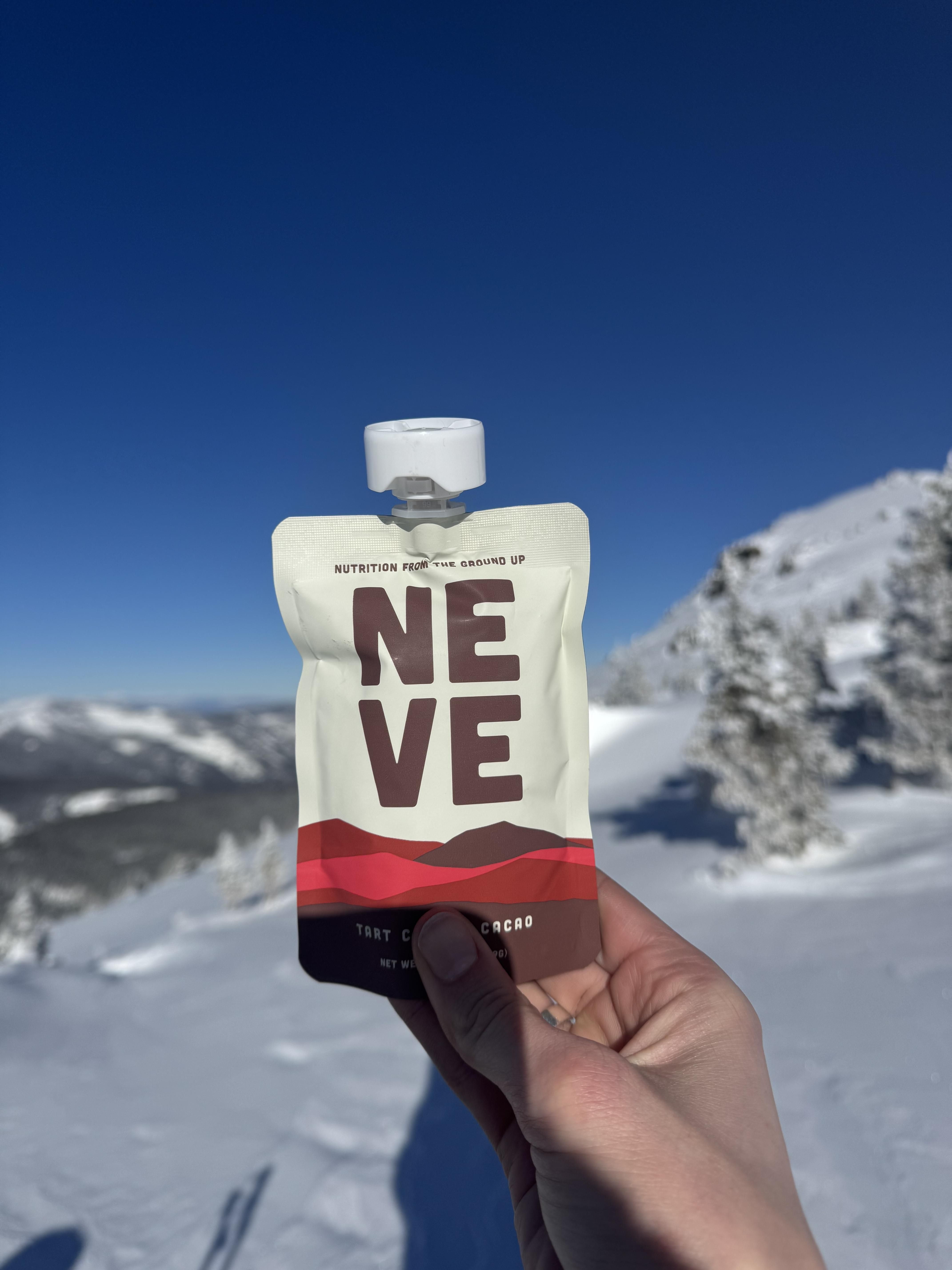 Tart Cherry Cacao Recovery Smoothie Pouch held up with snowy background