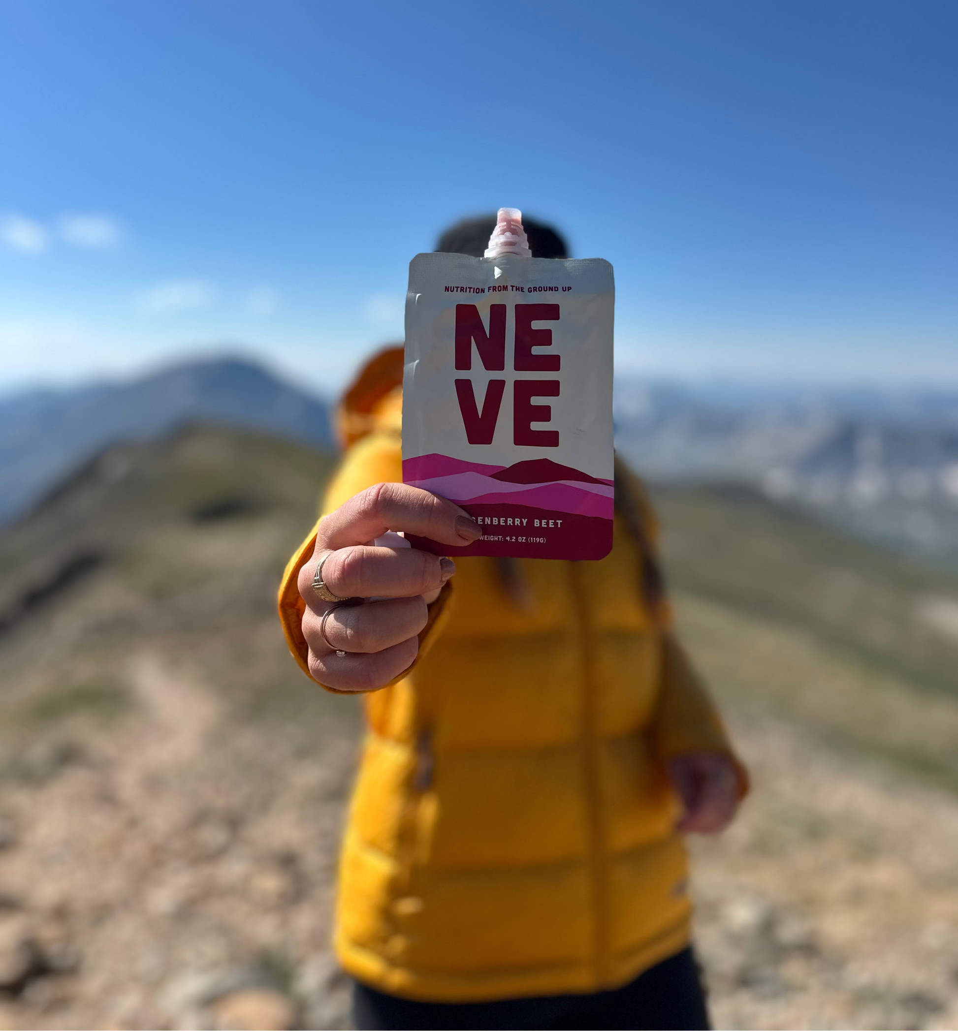 Ali holding Boysenberry Beet Neve Smoothie Pouch for quick and sustained energy. The best hiking snacks. 